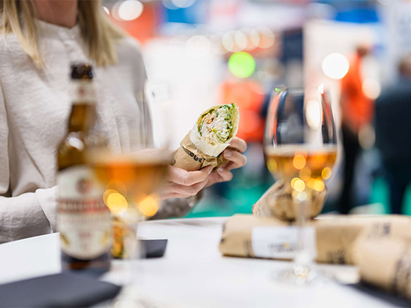 Måltid med wrap och dryck i mässmiljö.